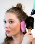 woman-using-misscareful-ear-covers-while blow-drying hair