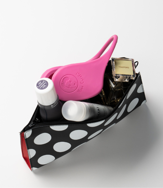 Pink color Miss Careful Ear Covers in a small black and white purse with other products