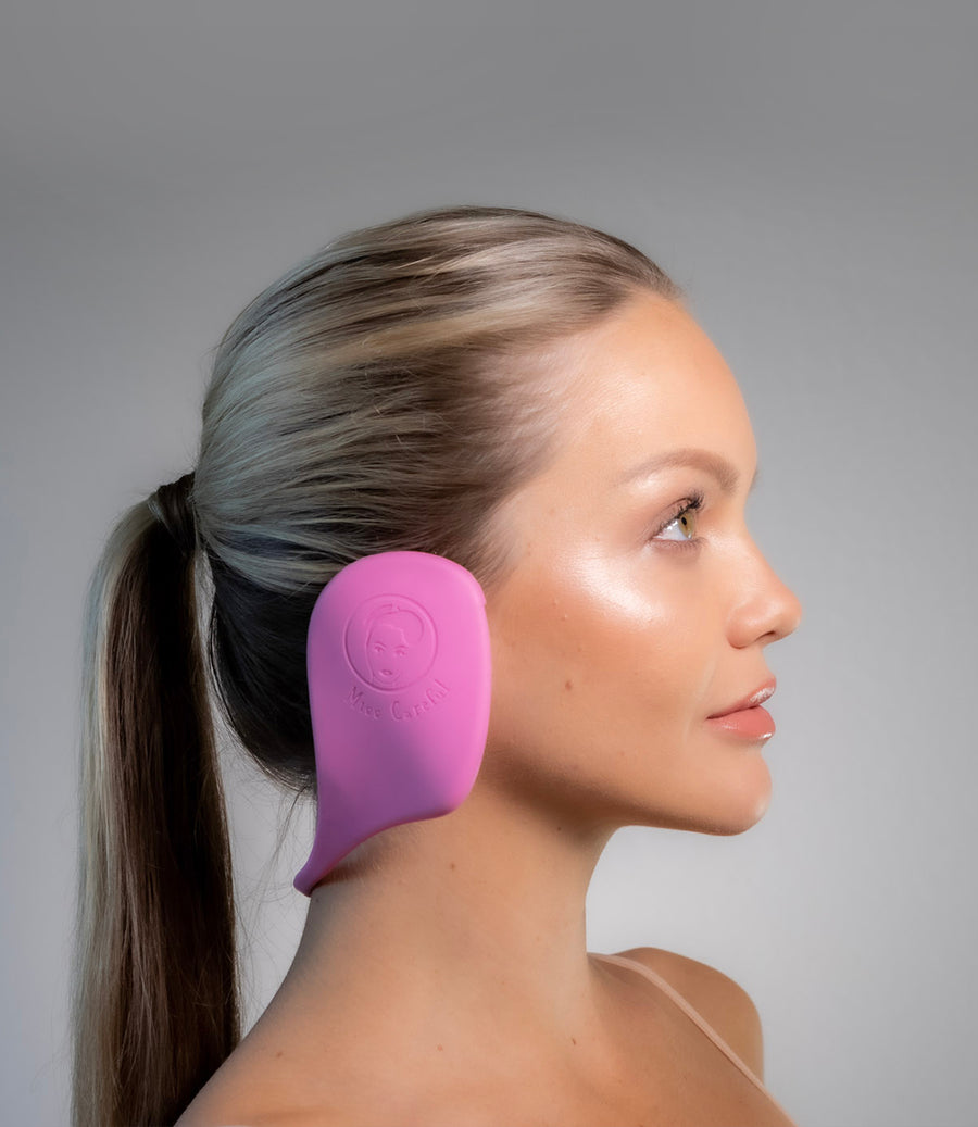 Side view of a white woman wearing pink color Miss Careful brand of Ear Covers on her ears